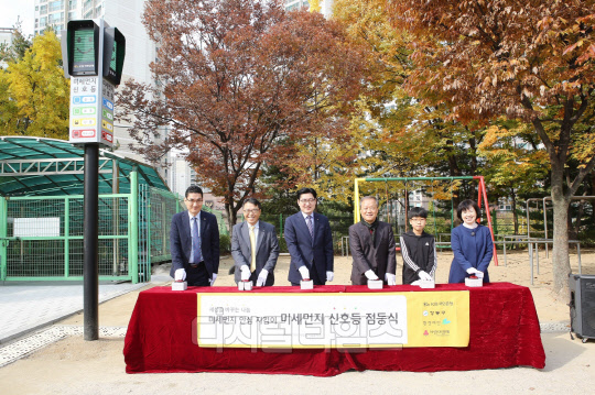 지난 5일, 서울 강동구 소재 명덕초등학교에서 열린  '미세먼지 신호등' 점등식에서 최웅철 KB국민은행 명일동지점장(왼쪽부터), 노상욱 KB국민은행 상일동지점장, 이정훈 강동구청장, 최열 환경재단 이사장, 박은순 명덕초등학교장(오른쪽)이 점등버튼을 누르고 있다. KB국민은행 제공